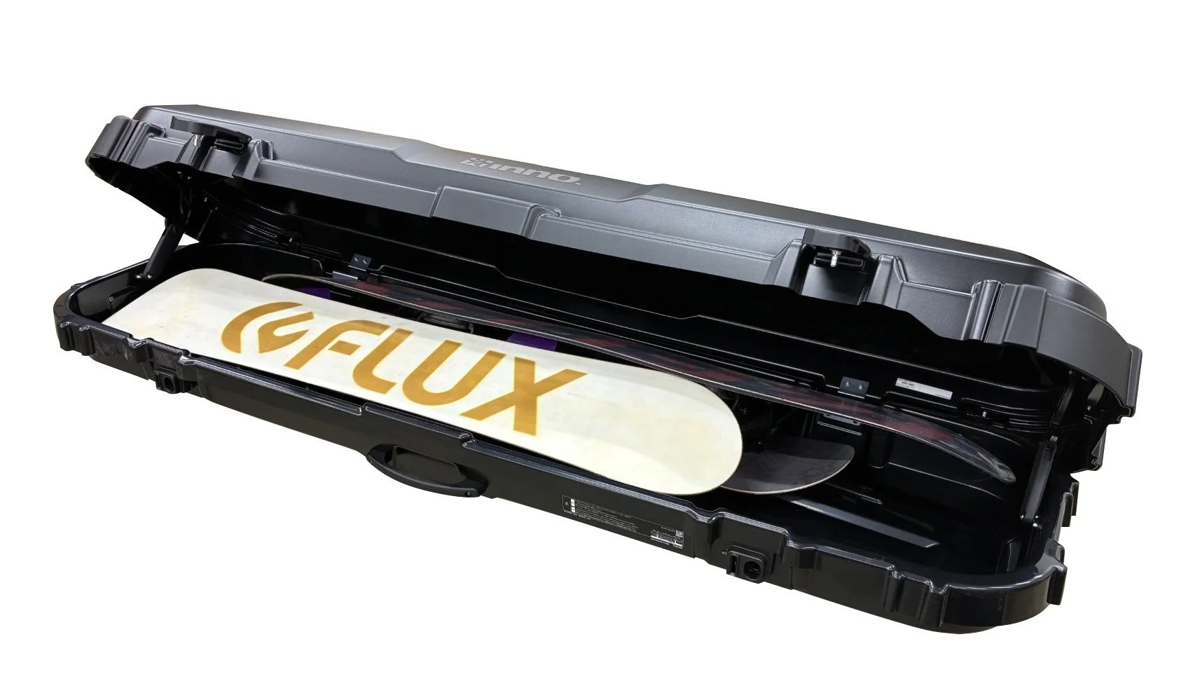 黒いルーフボックスが少し開いた状態で、中に「FLUX」のロゴが入ったスノーボードが収納されている様子を写した画像です。ウィンタースポーツ用品の運搬・収納に便利な製品です。