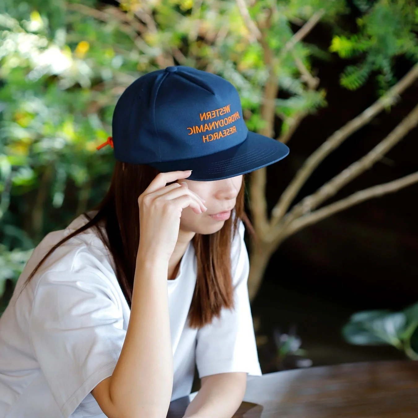 白Tシャツとキャップを着用した女性