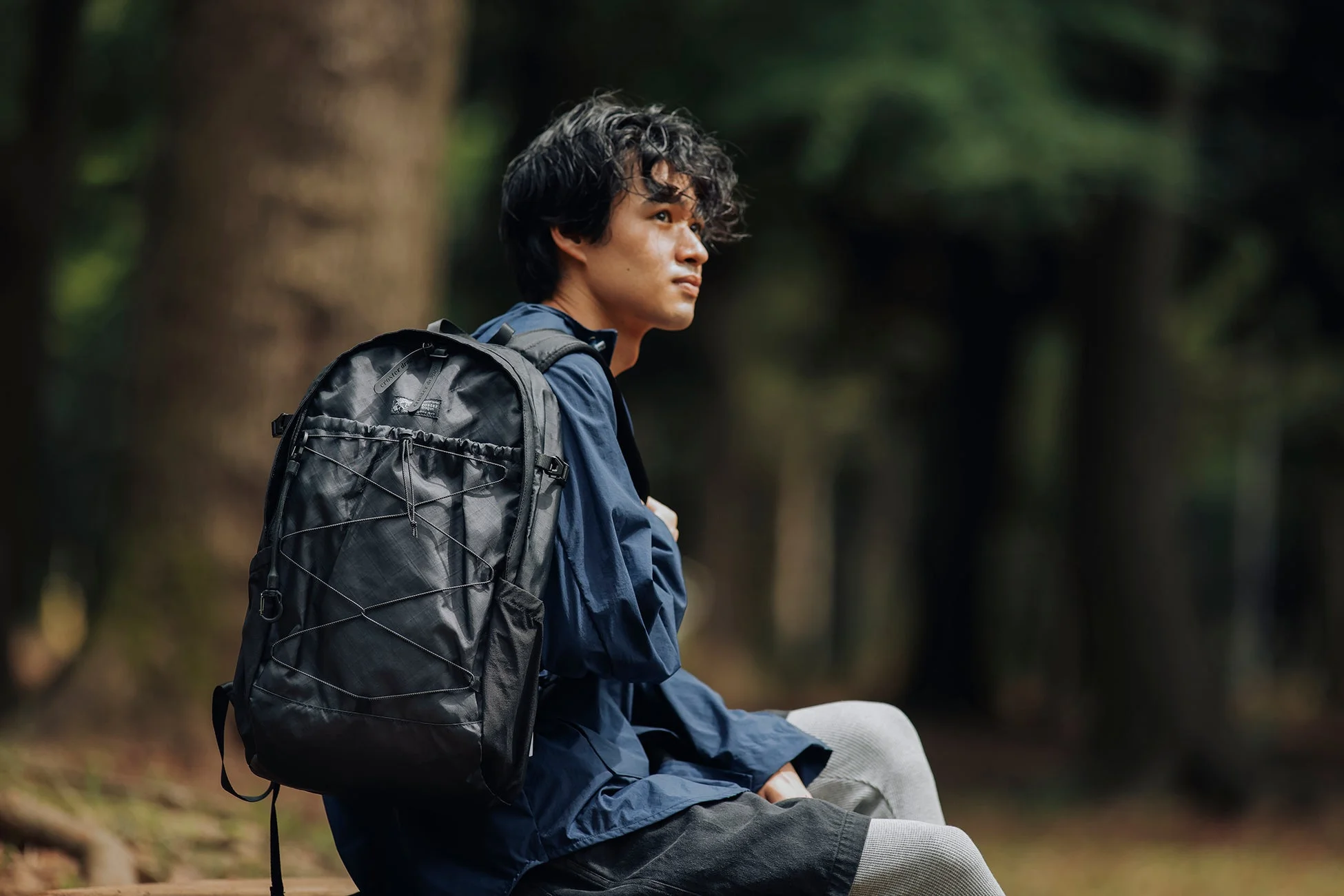 自然の中で黒いバックパックを背負う男性