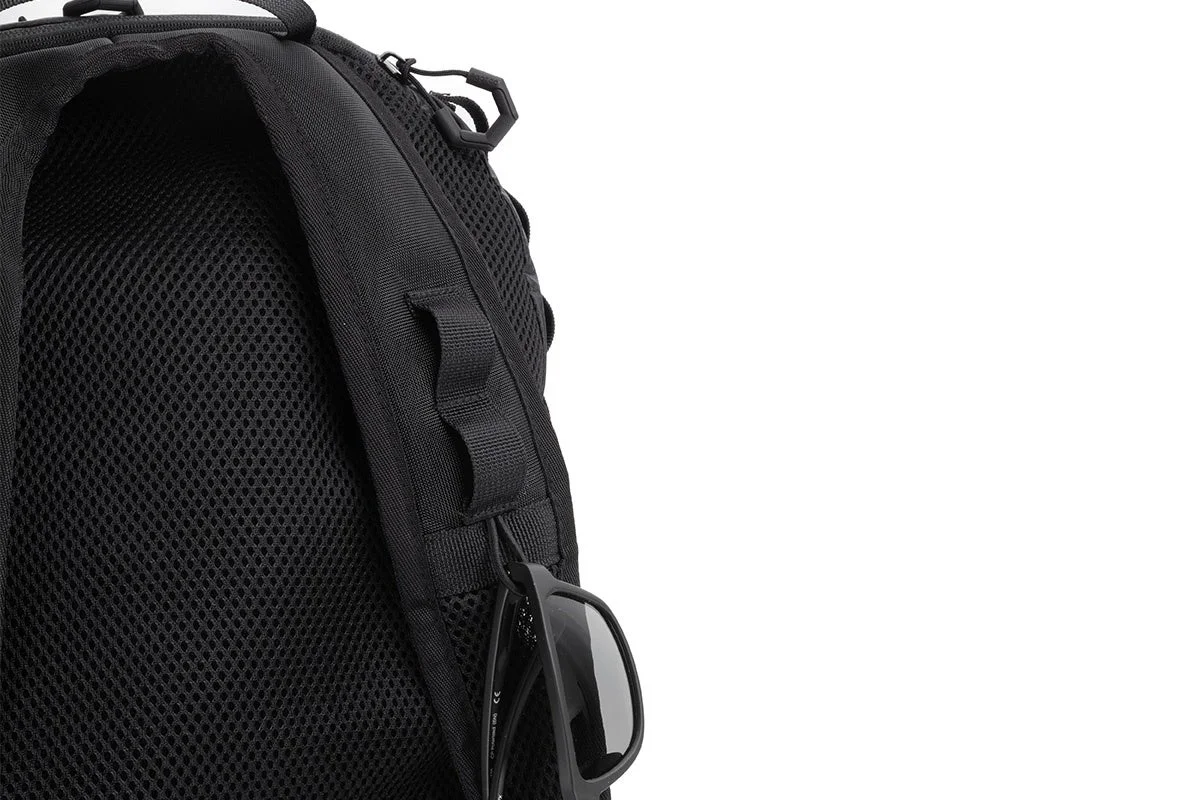 黒いリュックサックのショルダーストラップに黒いサングラスが掛けられている