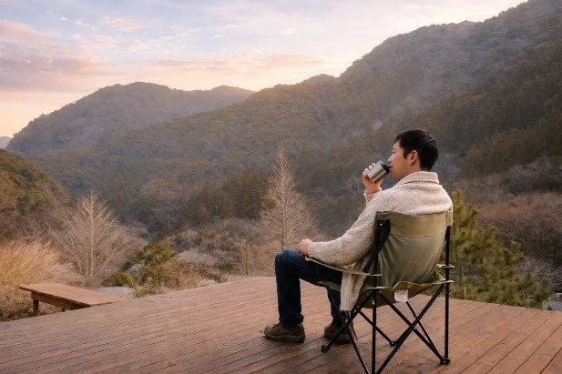 デッキでコーヒーを飲む男性