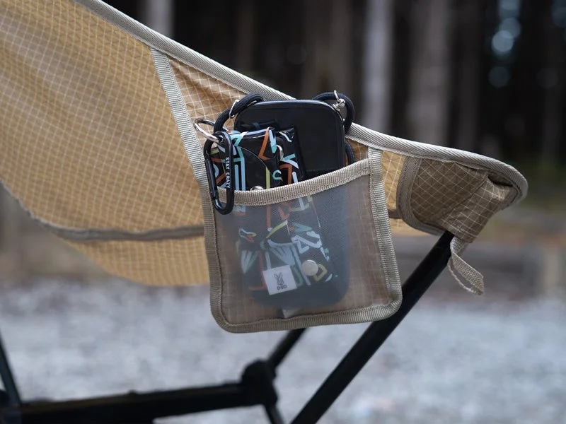 キャンプチェアのサイドポケットに小物が収納された様子