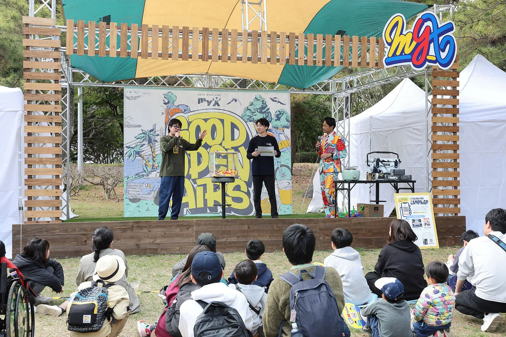 屋外のステージでイベントのプレゼンテーションが行われている様子