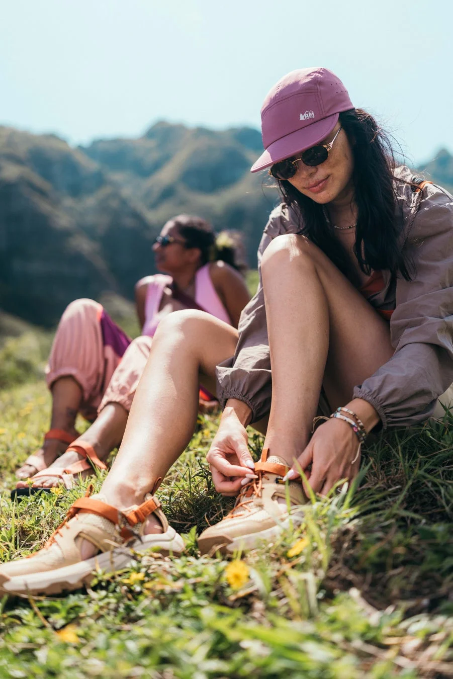 山々を背景に、草地に座ってくつろぐ2人の女性