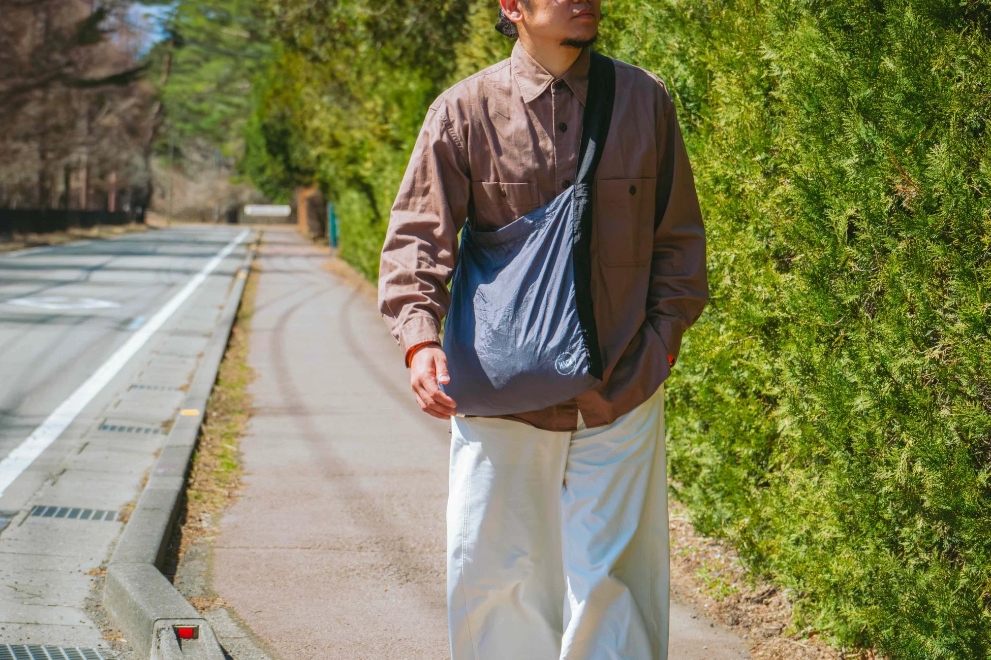 「SUMI」カラーのエコバッグを肩掛けする男性