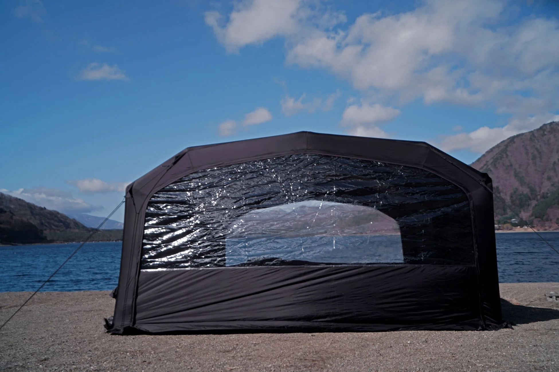 湖畔に設置された黒いテントと透明窓