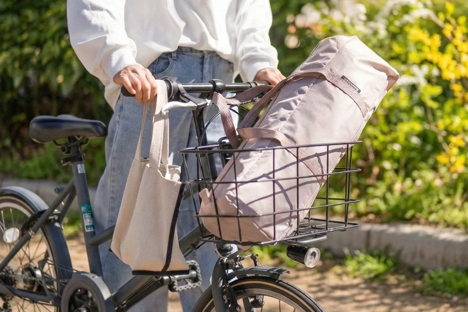 晴れた日に自転車を押して歩く人物の様子