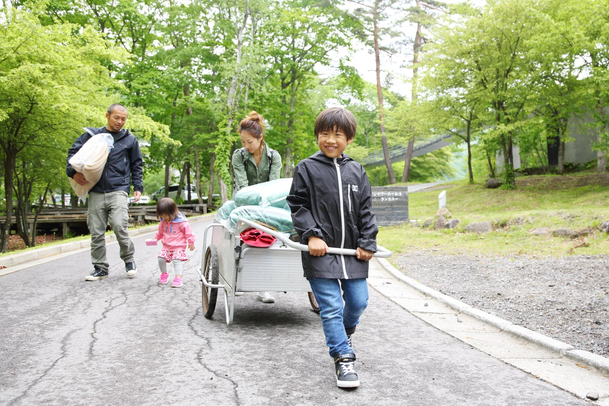 カートで荷物を運ぶ家族