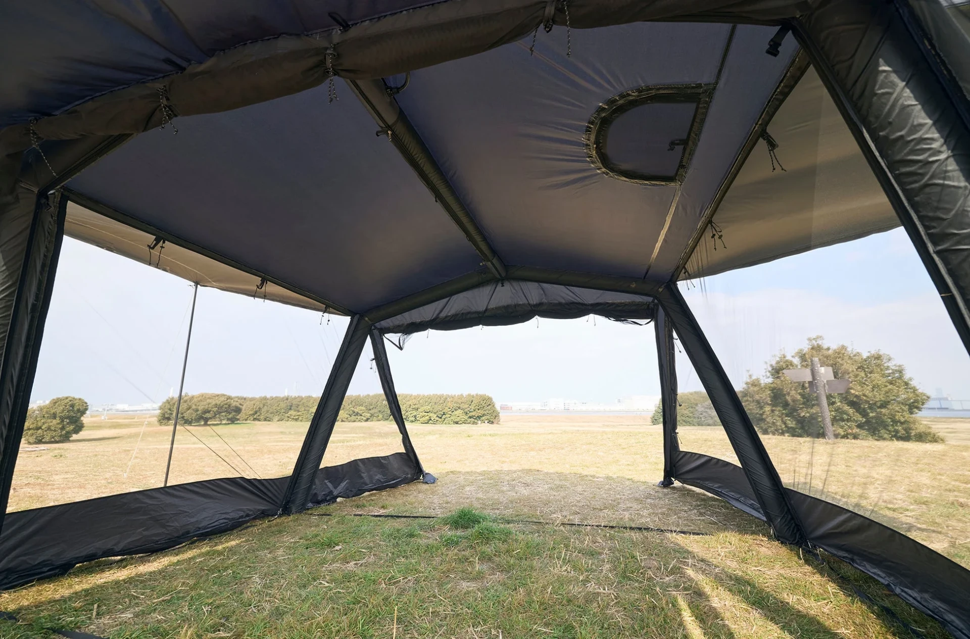 テントの中から広々とした草地の景色を捉えた写真