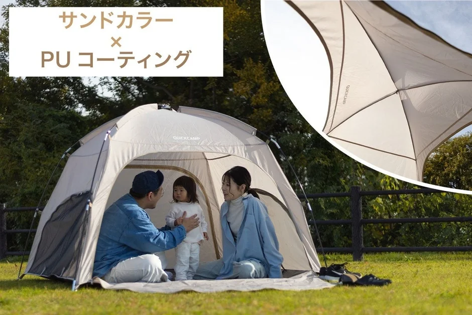 サンドカラーのテントの中で、父親、母親、小さな子供が楽しそうに過ごしている様子