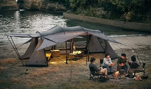 川辺でキャンプを楽しむ人々