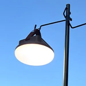 青空を背景に、明るく点灯している屋外用のランプが写っています