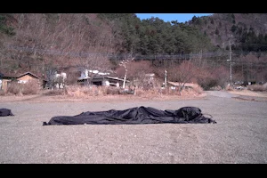 砂利の上に横たわる黒い布状の物体とポンプ