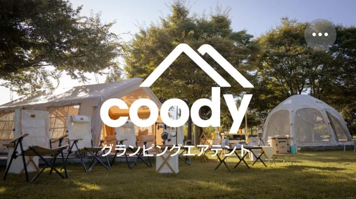 広々とした芝生の広場に設置された大型のグランピングテントと、その周りに並べられたキャンプチェアやテーブルが写っています。自然豊かな環境での快適なアウトドア体験を提案しているようです。