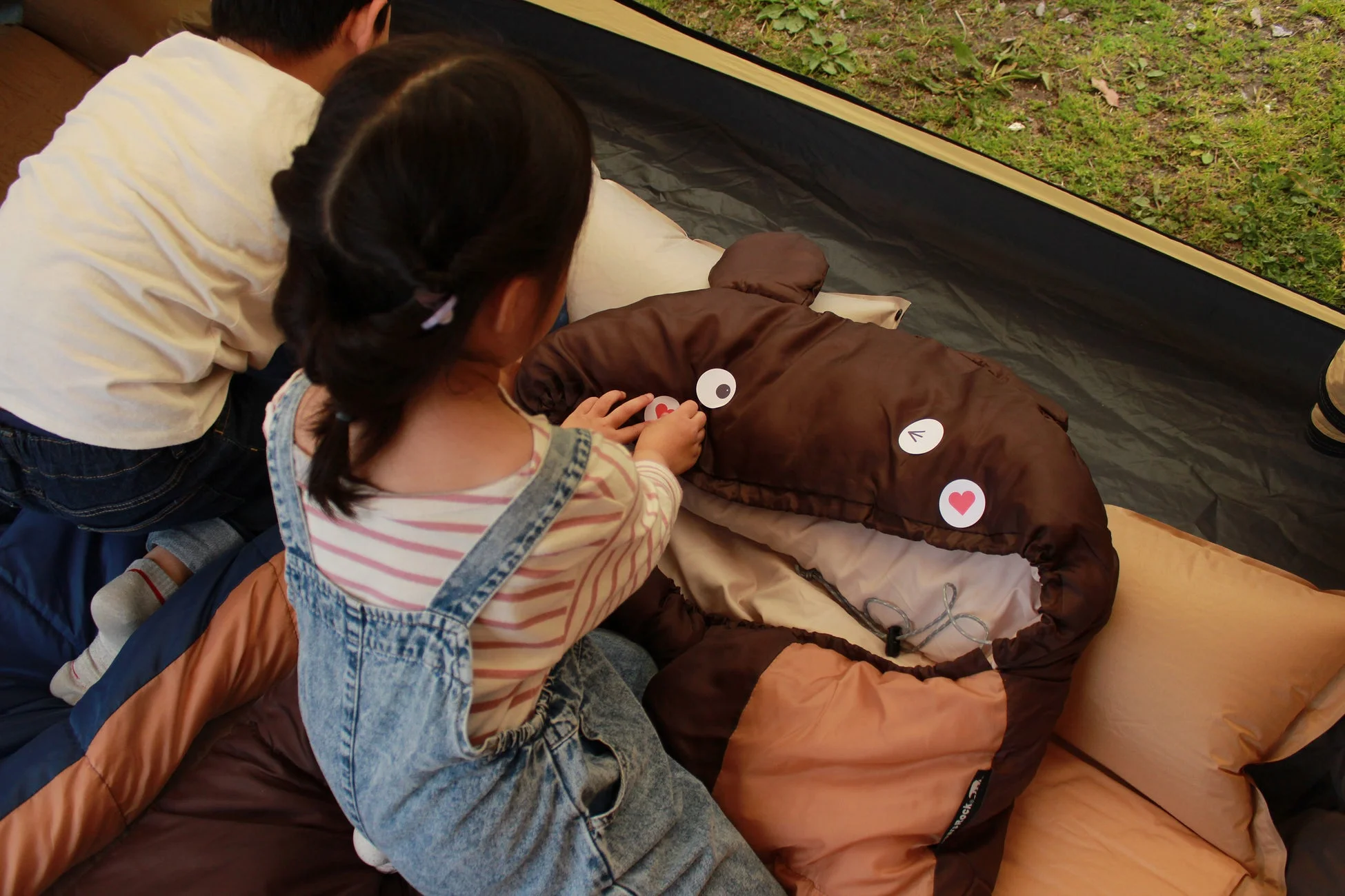 女の子が寝袋にシールを貼っている