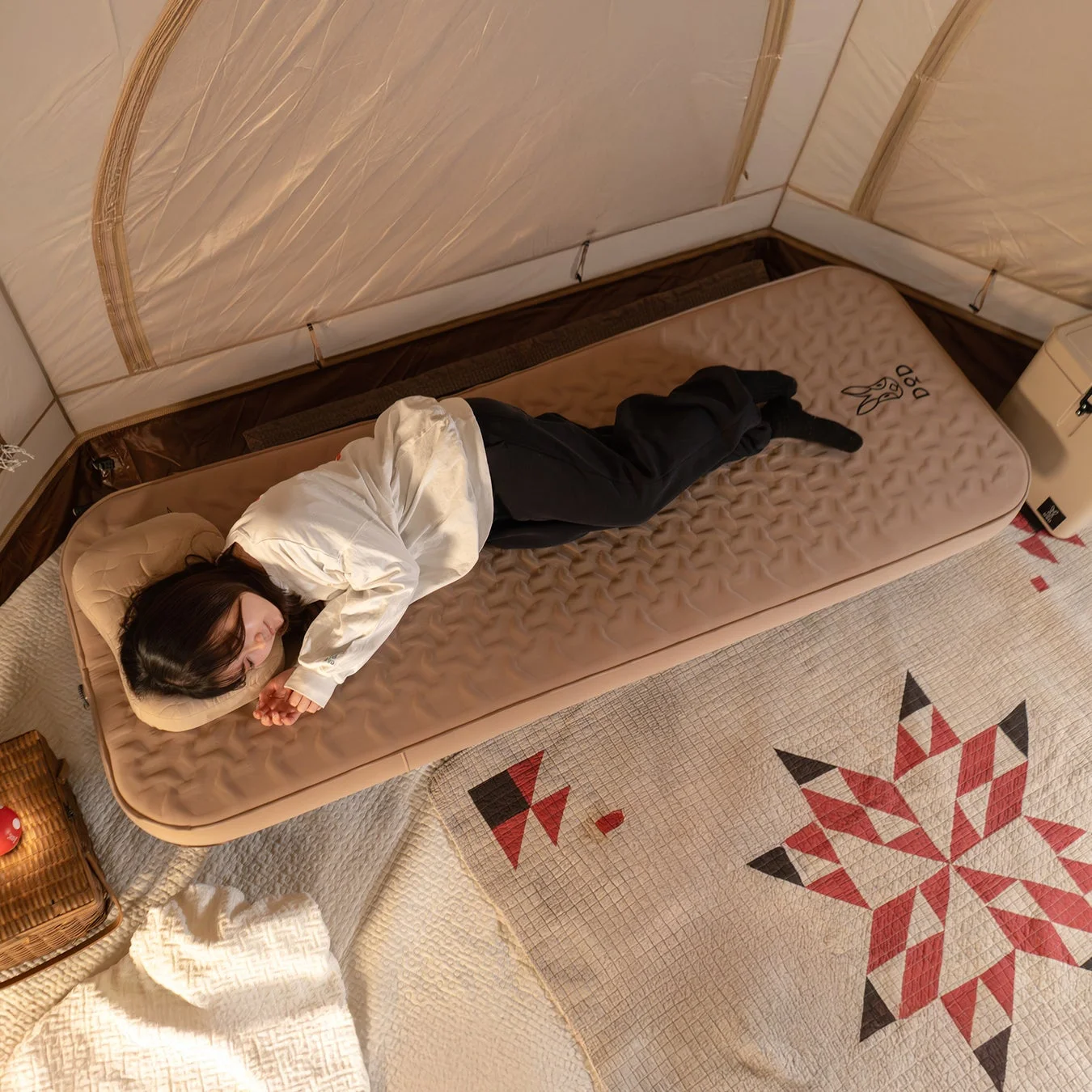 テント内でエアマットの上で眠る女性