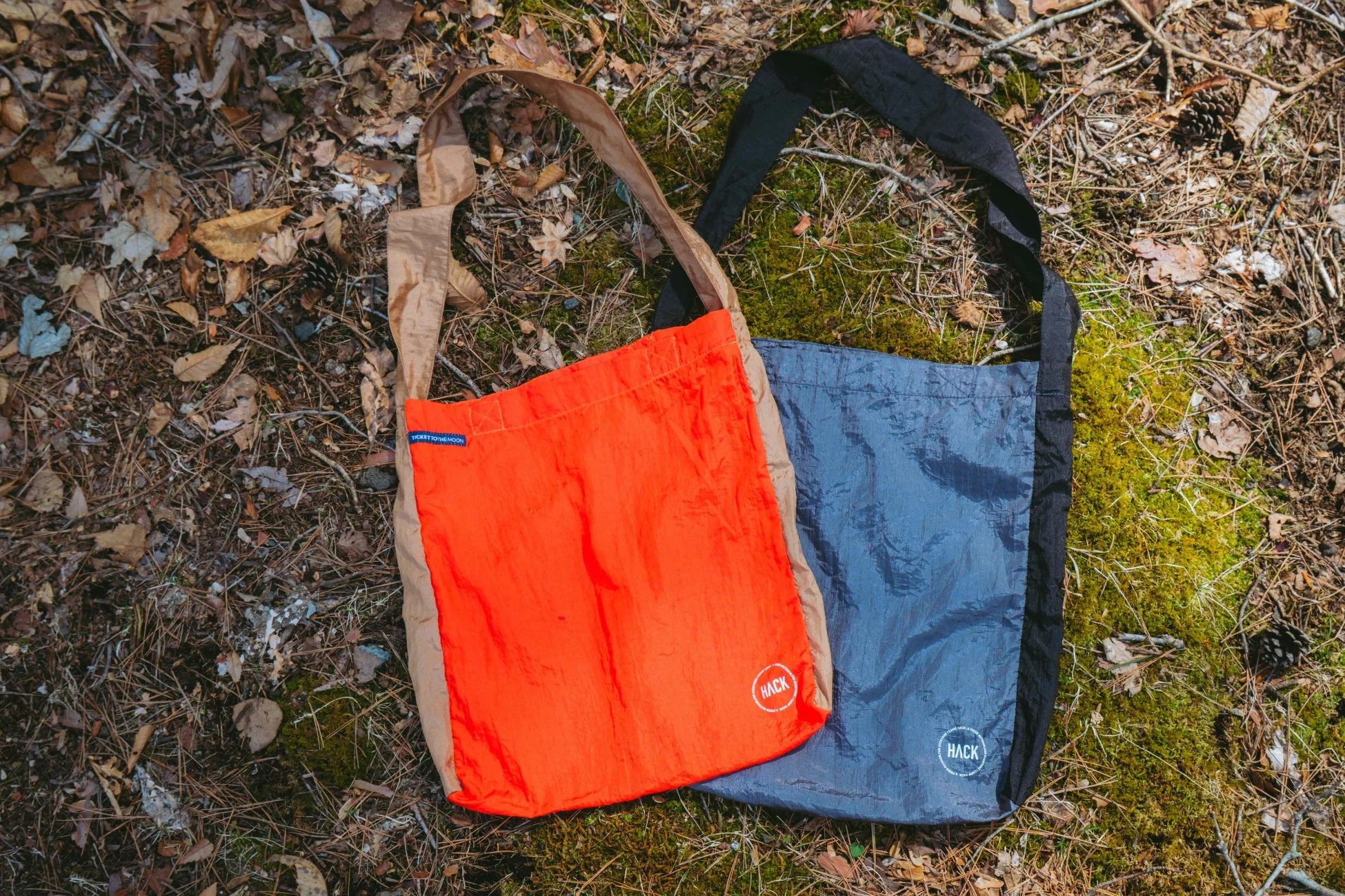 オレンジとグレーのエコバッグが地面に置かれている様子