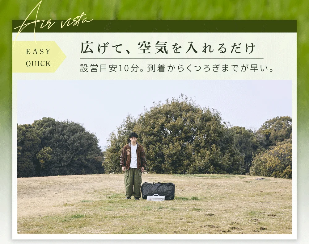 広大な芝生の広場で、男性が設営が簡単なエアテントの前に立っている様子