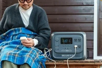 屋外でポータブル電源を使ってスマートフォンを充電する様子