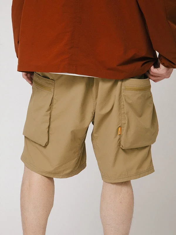 ベージュのカーゴショーツを着用した人物