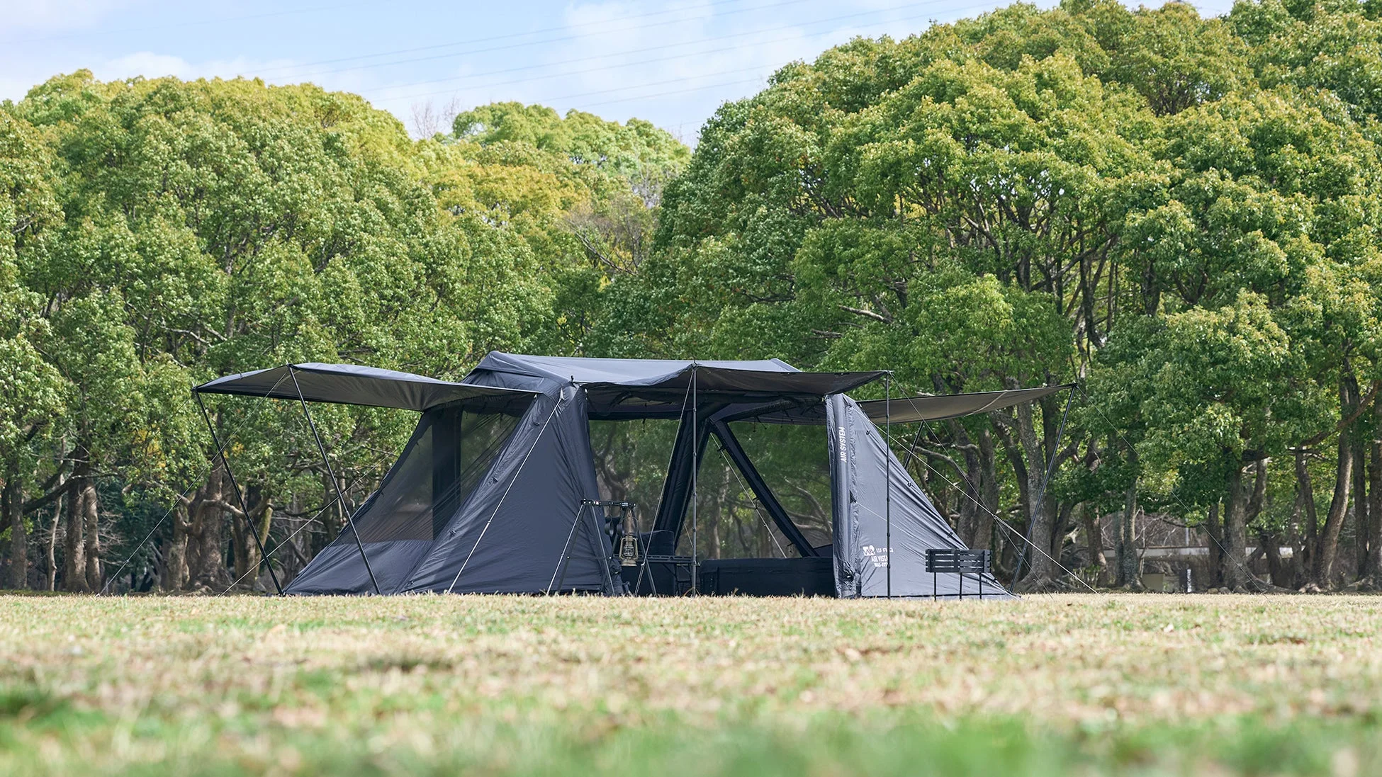 広々とした芝生の上に、グレーの大型テントが設営されている様子