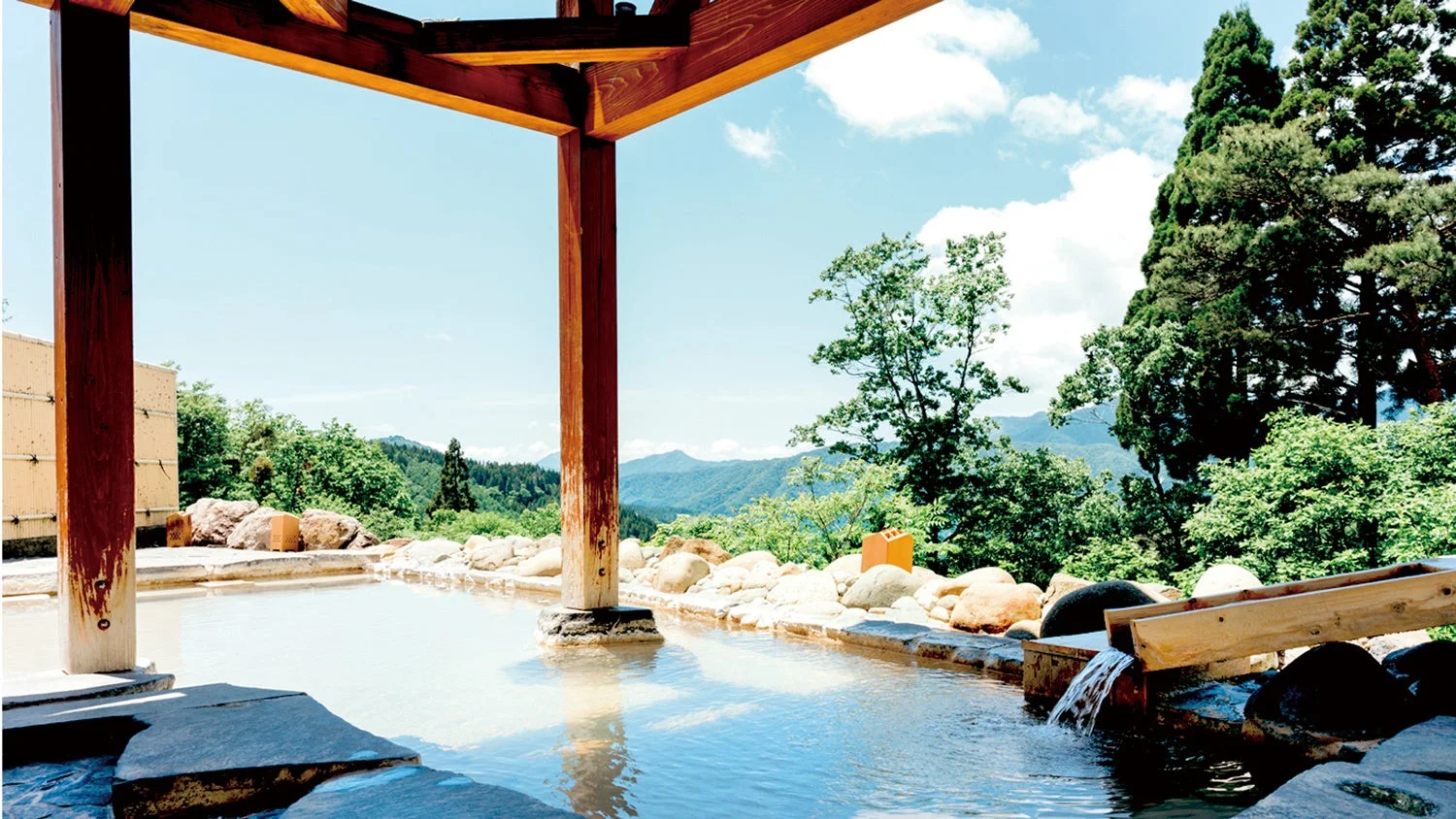山々や豊かな自然を背景に広がる開放的な露天風呂の風景