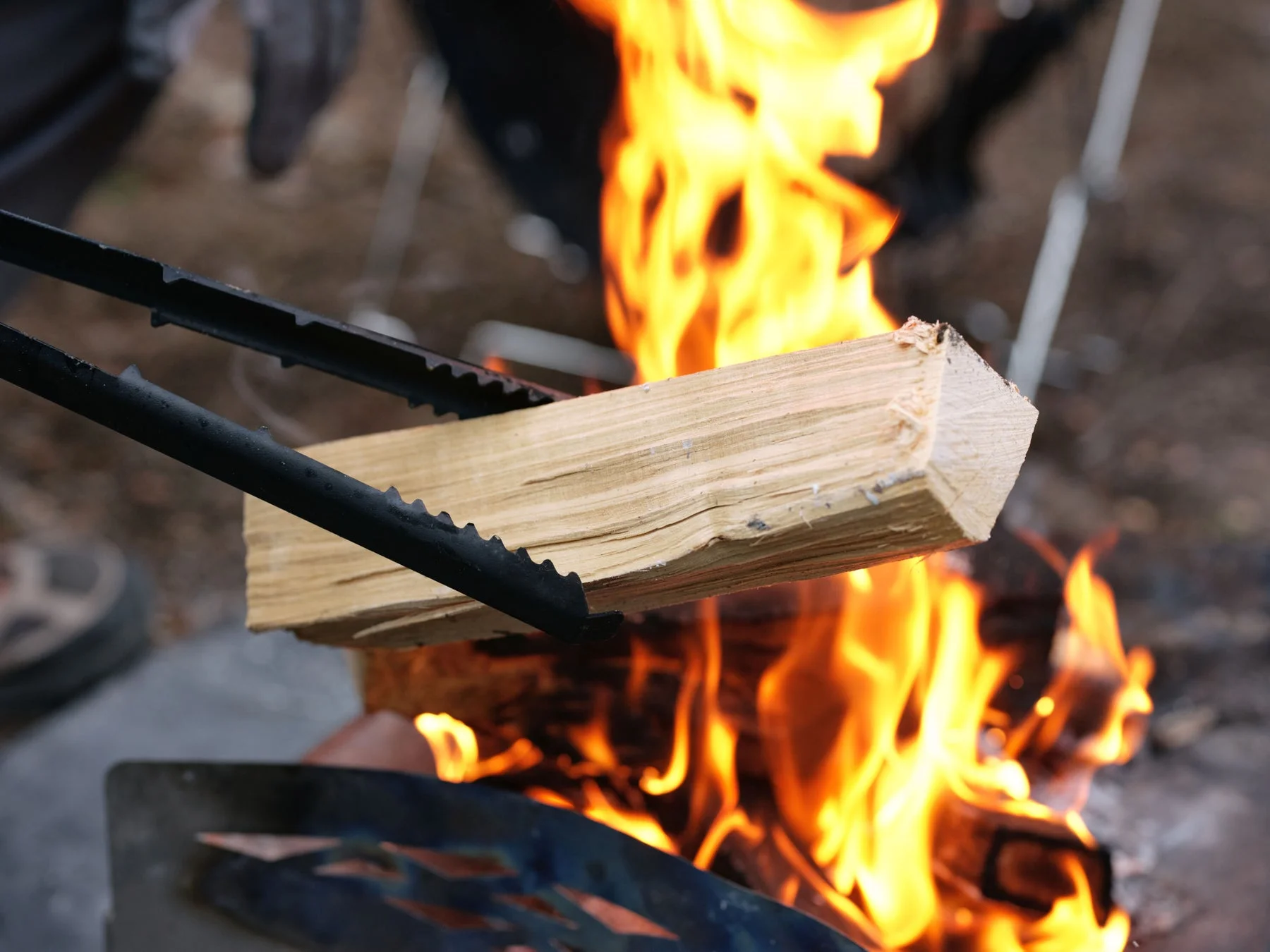 焚き火に薪をくべる様子