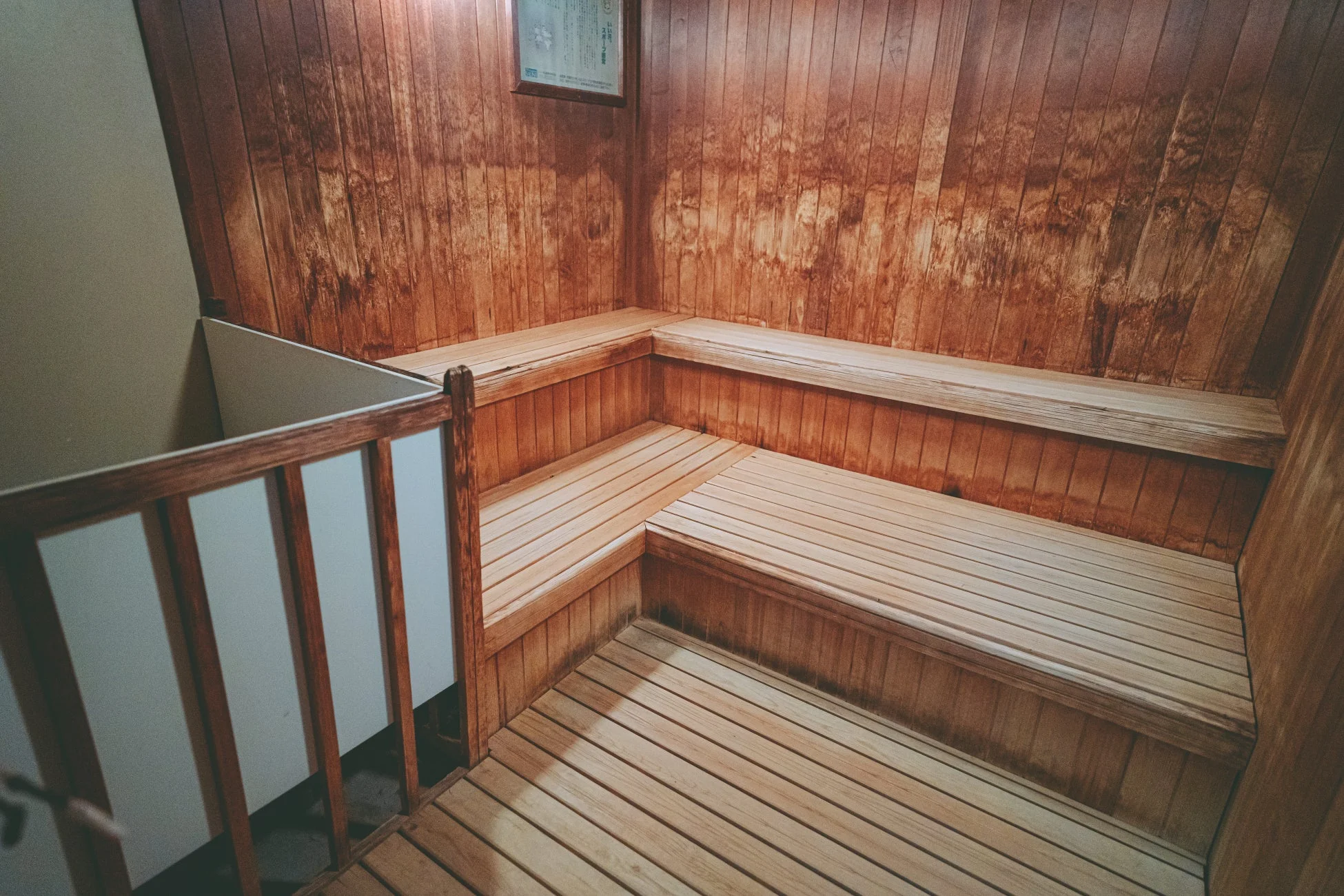 木製の壁とベンチ、スラット状の床が特徴のサウナ室内部