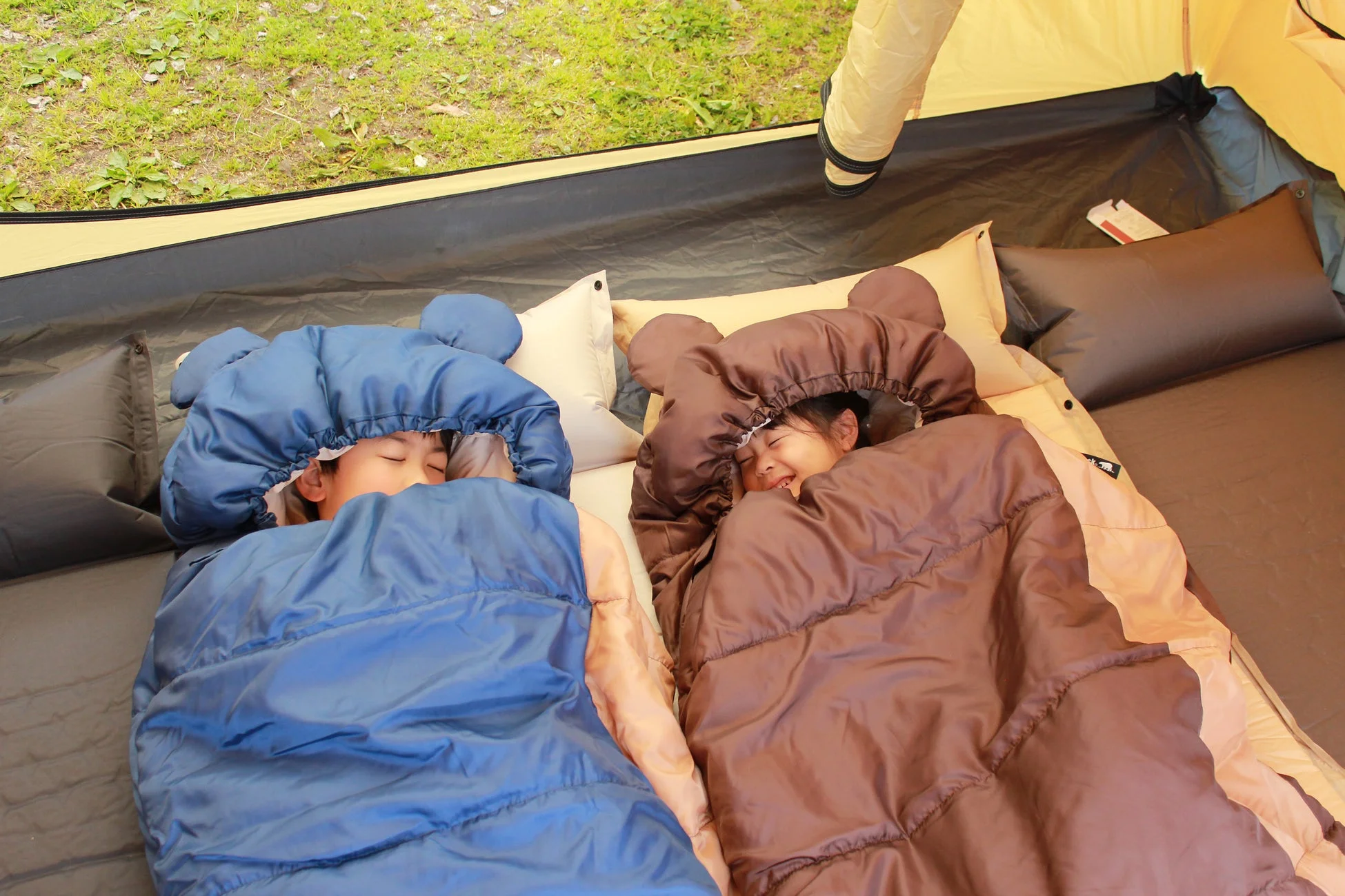 テントの中で、クマ耳の寝袋に入って眠る2人の子供たち