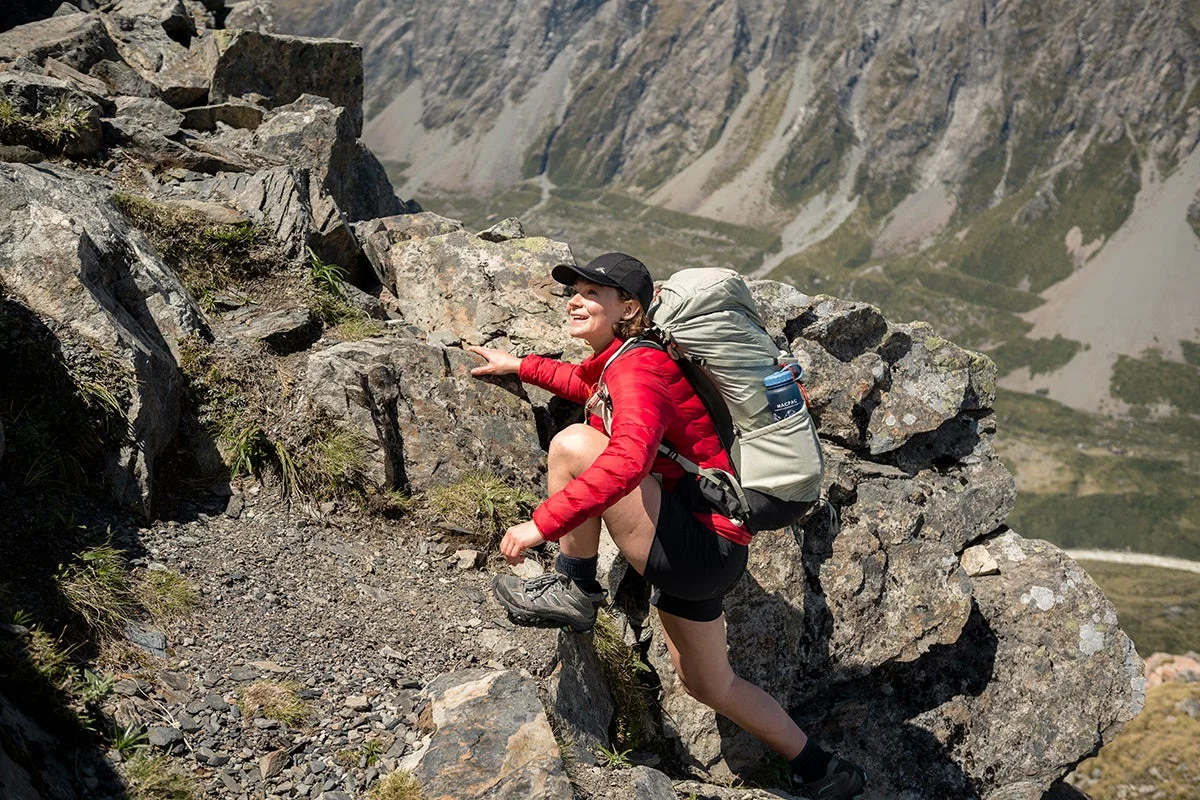 山道を登る女性とバックパック