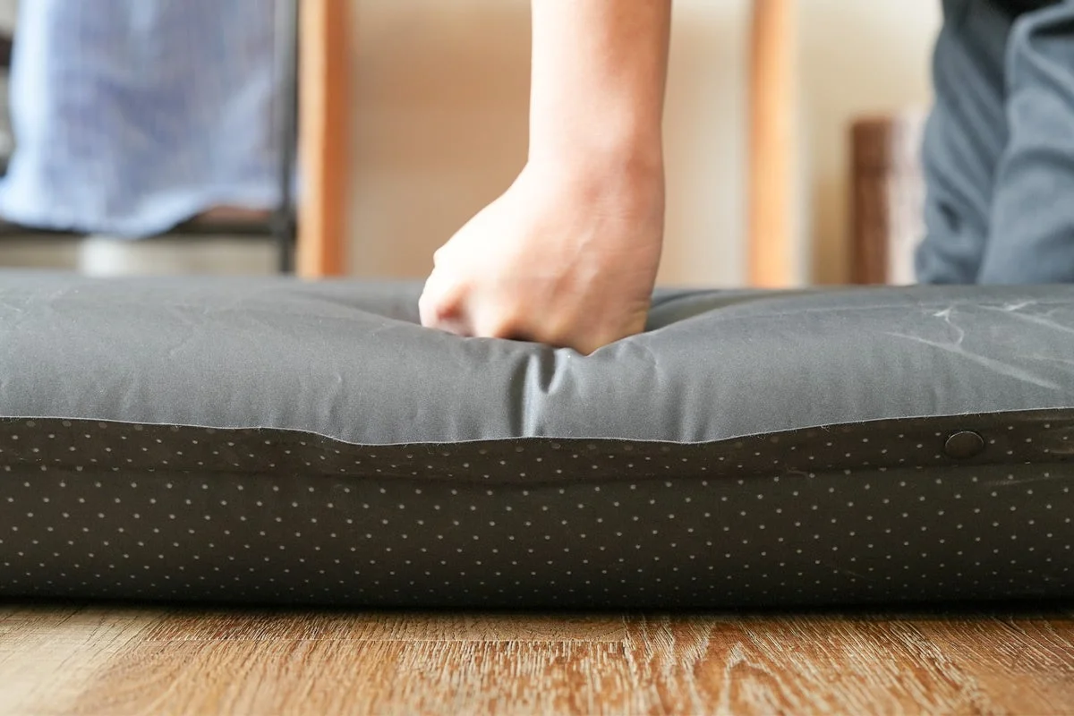 手がクッションの柔らかさを試す