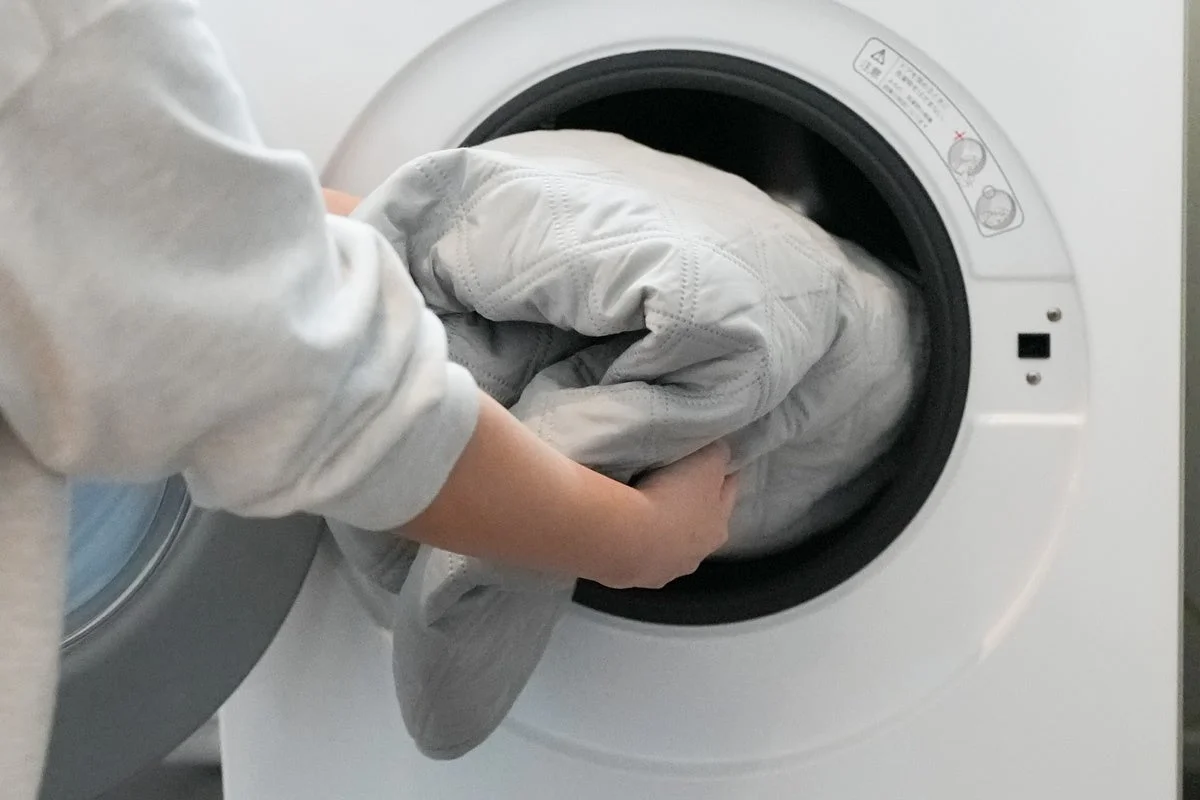 キルティングの毛布をドラム式洗濯機に入れている様子
