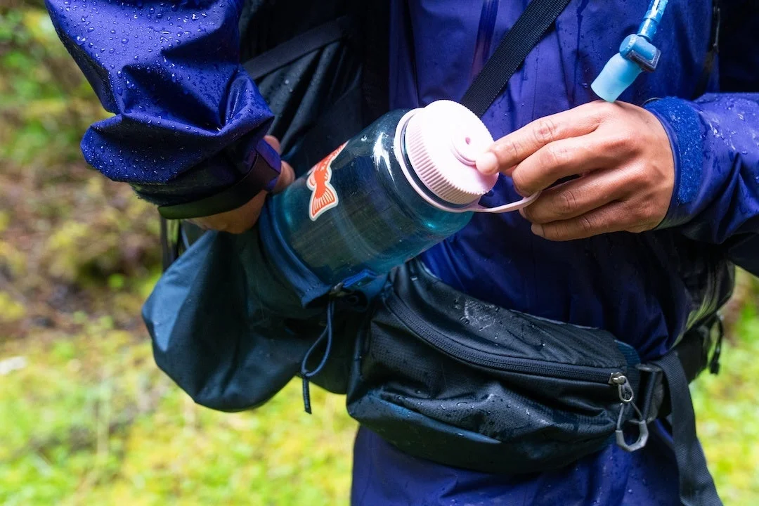 雨の中ボトルで水分補給する人