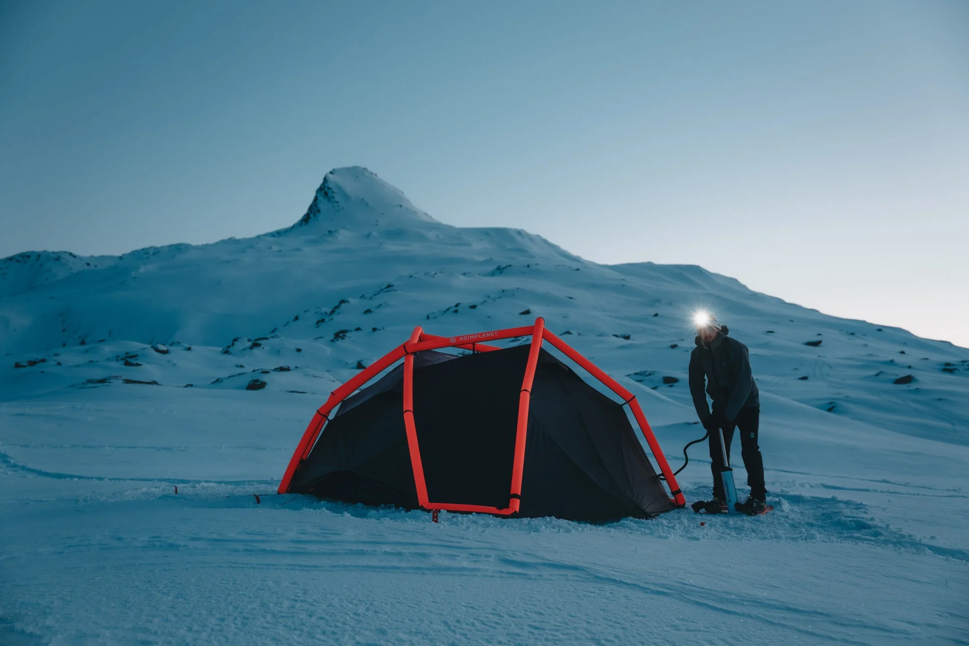 雪山で設営中のテント