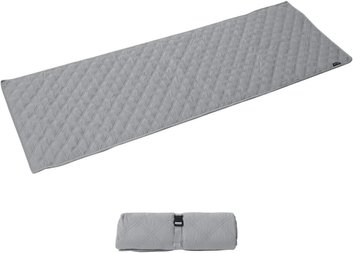 グレーのキルティング加工されたマットが、広げた状態とコンパクトに丸めてストラップで固定された状態で写っています