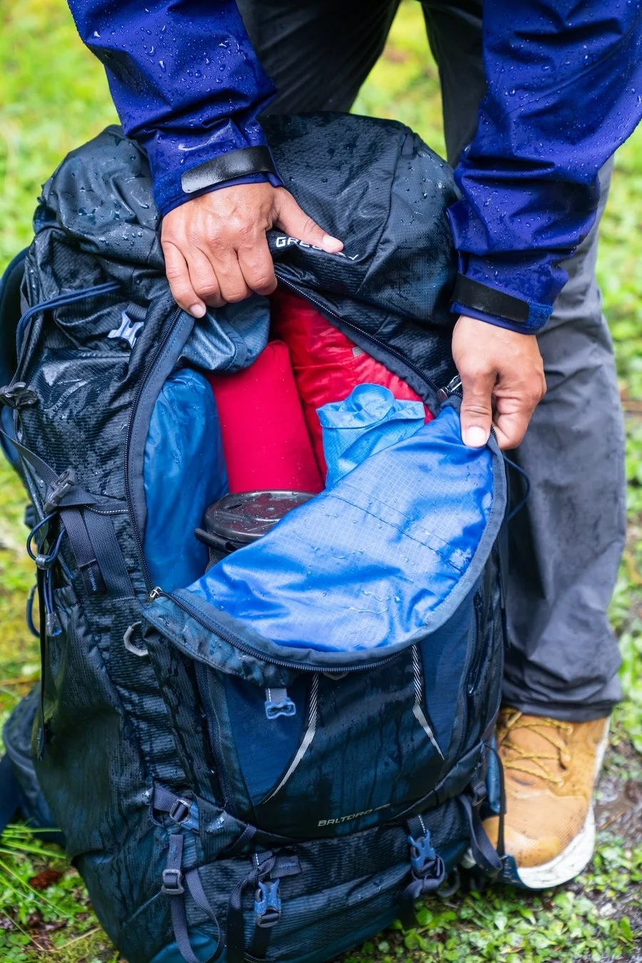 雨の中バックパックを整理する人