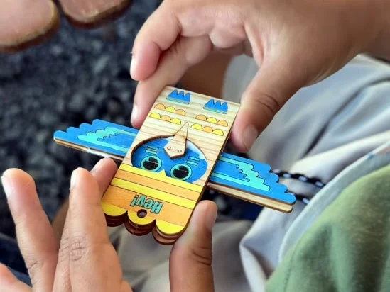 子供が両手で木製の鳥のおもちゃを持っているクローズアップ画像