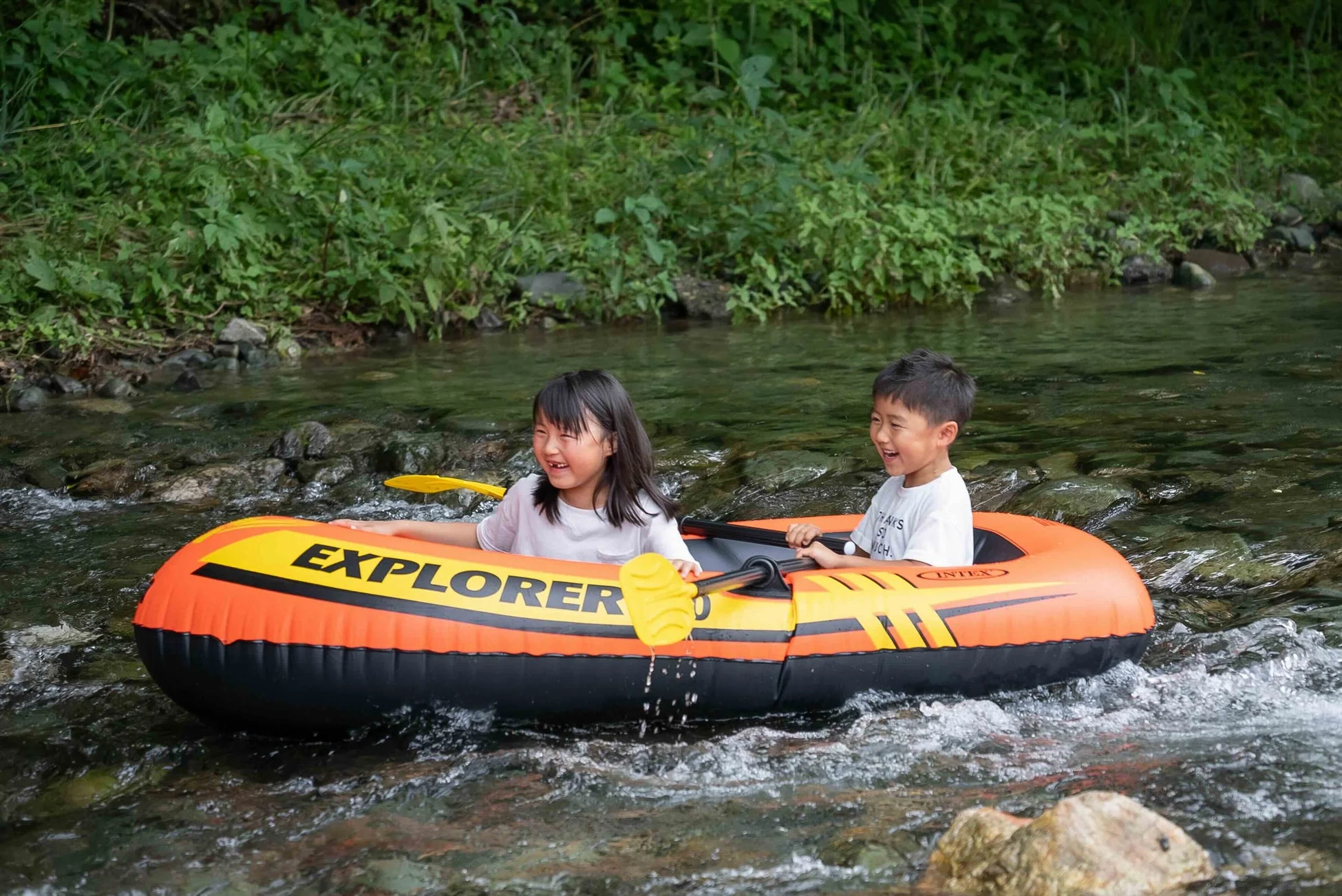 川でボート遊びを楽しむ子どもたち