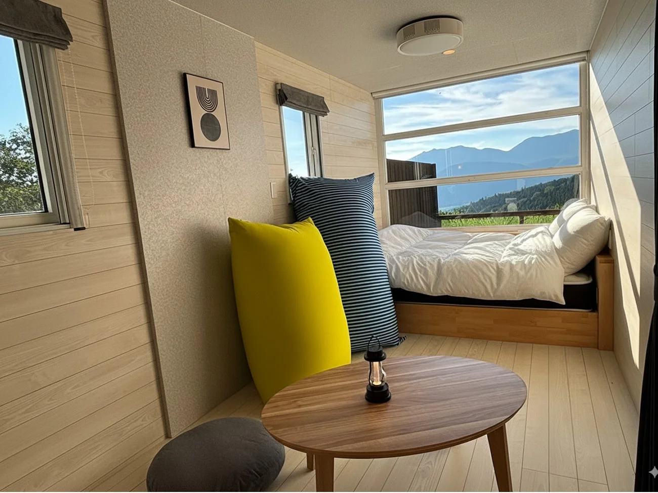 山々を望む大きな窓がある、明るくモダンな宿泊施設の部屋