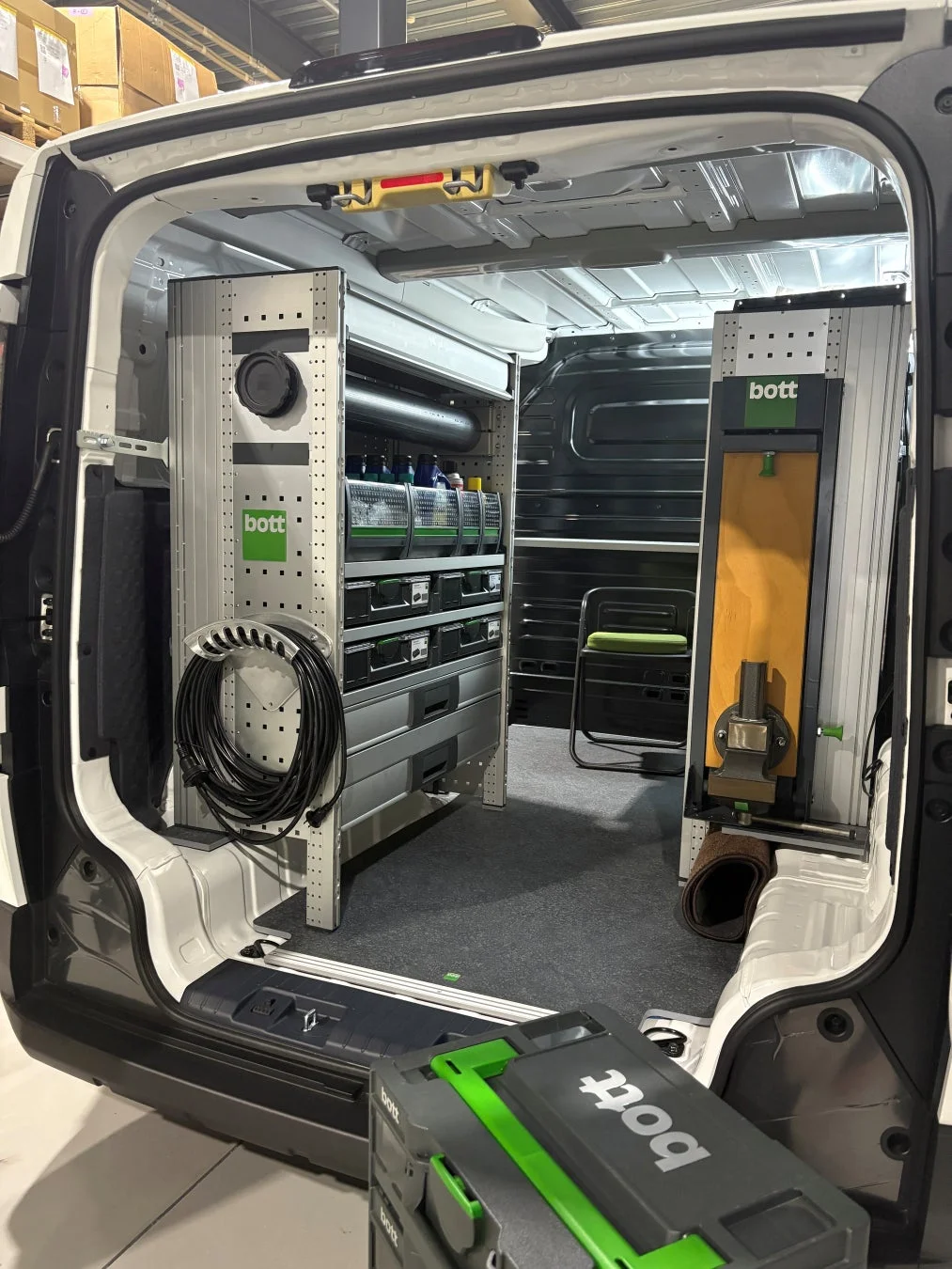 プロフェッショナルな作業用にカスタマイズされ、整理整頓された商用バン（サービスカー）の荷室が写っています。