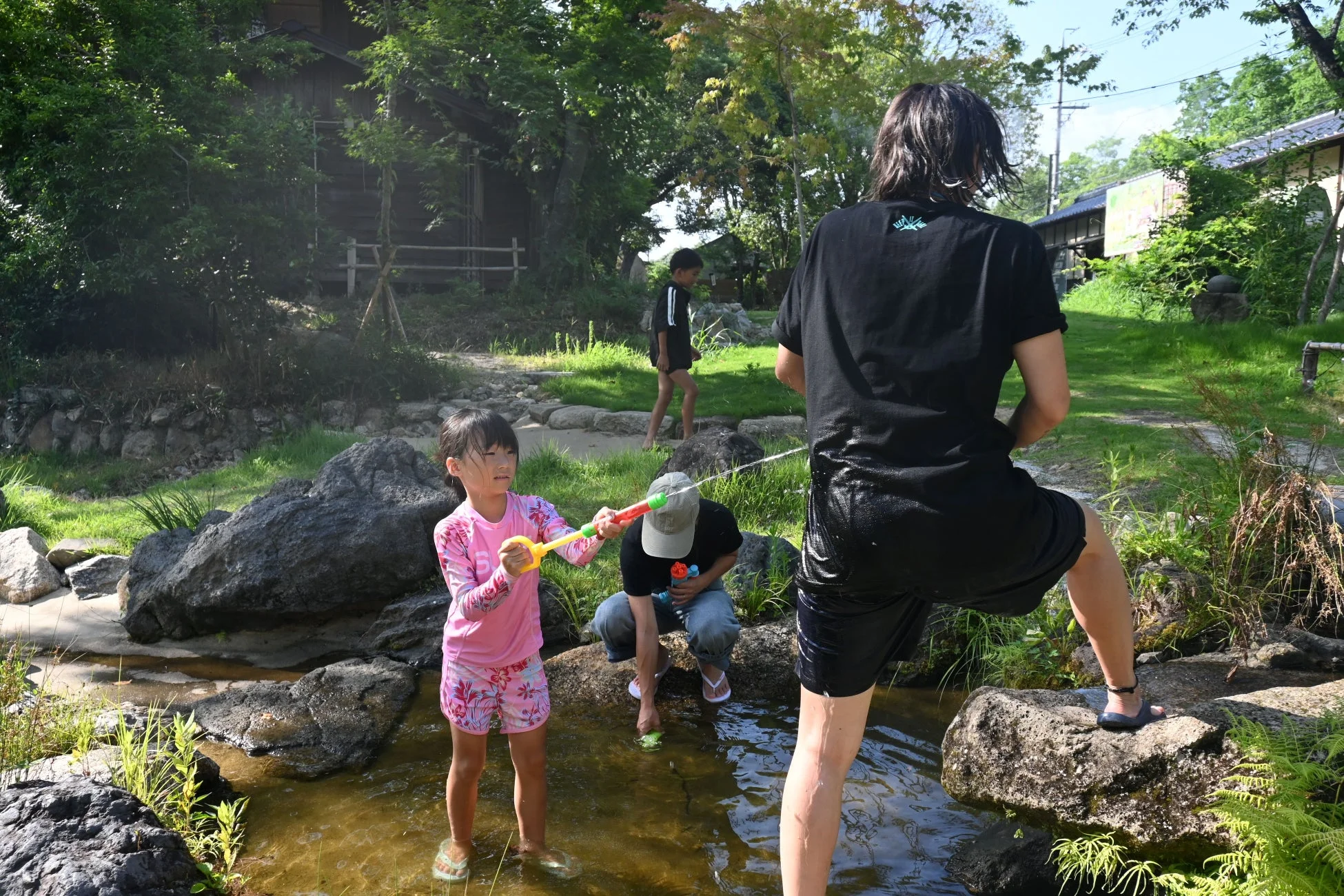自然豊かな場所で、子供たちが水遊びを楽しんでいます。