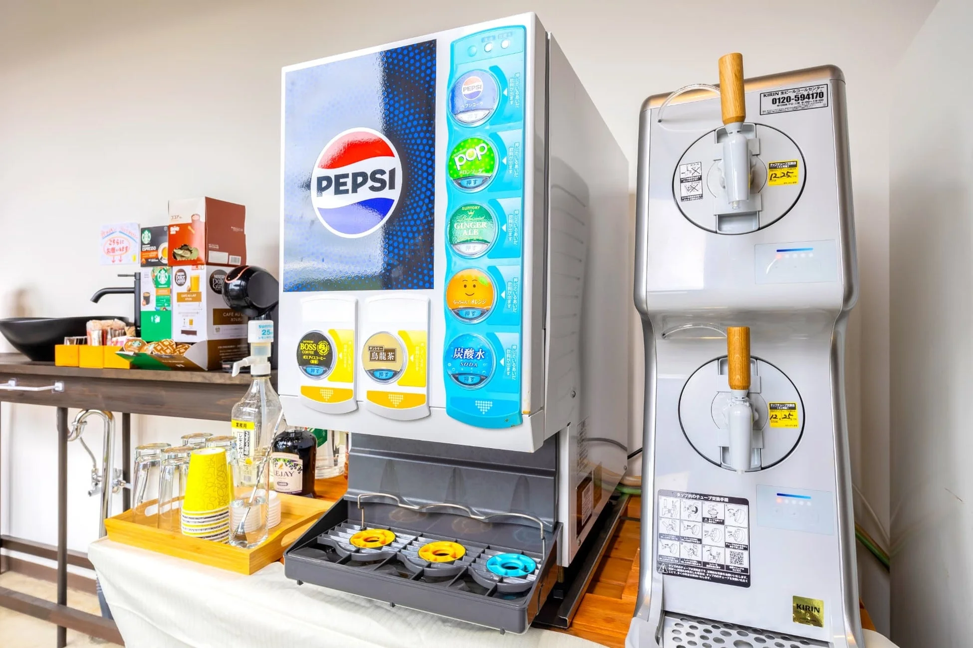 ドリンクディスペンサー、コーヒーメーカー、キリンのビールサーバーが並ぶセルフサービスのドリンクコーナー
