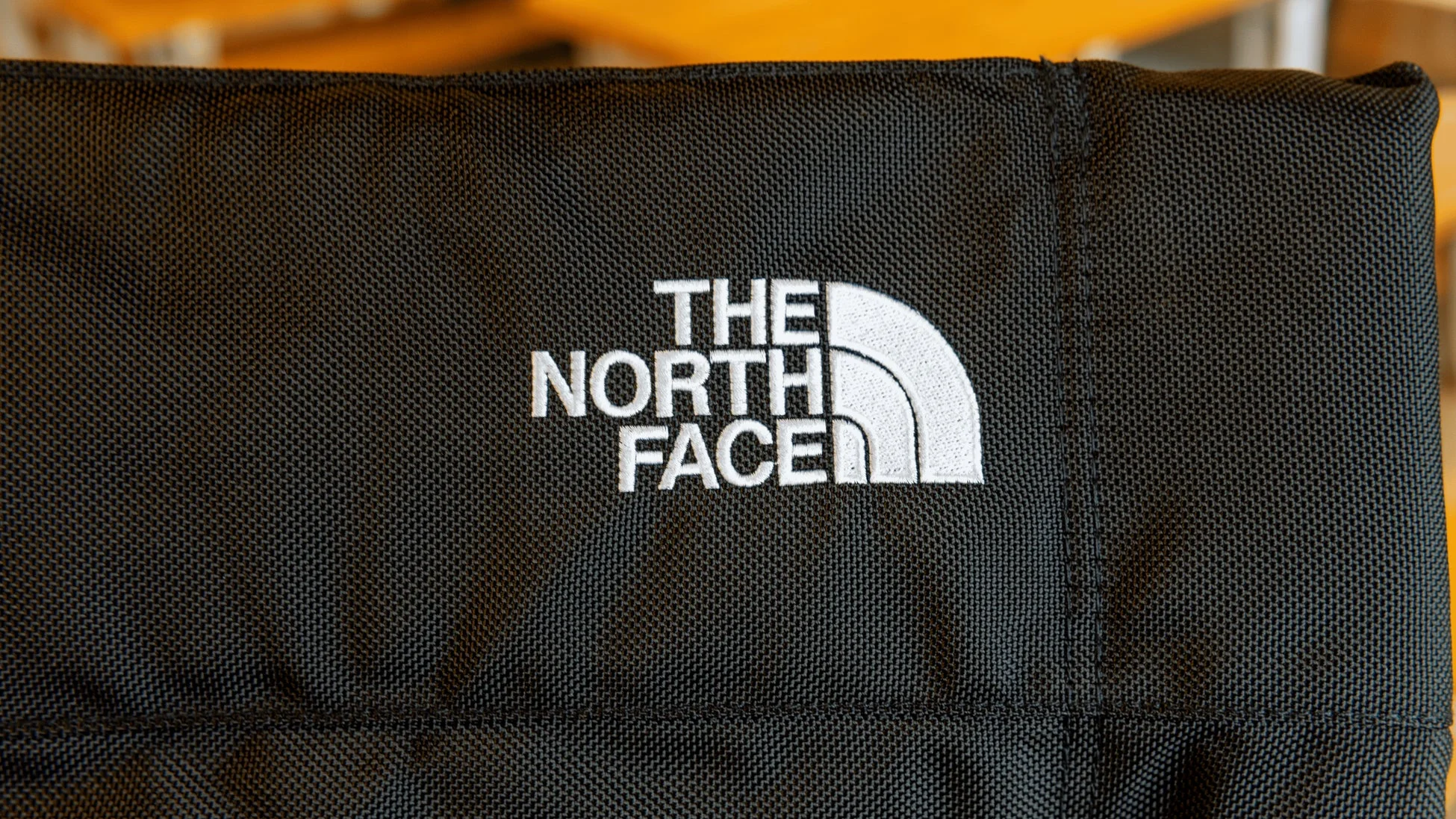 黒い生地に白い糸で刺繍された「THE NORTH FACE」ロゴ