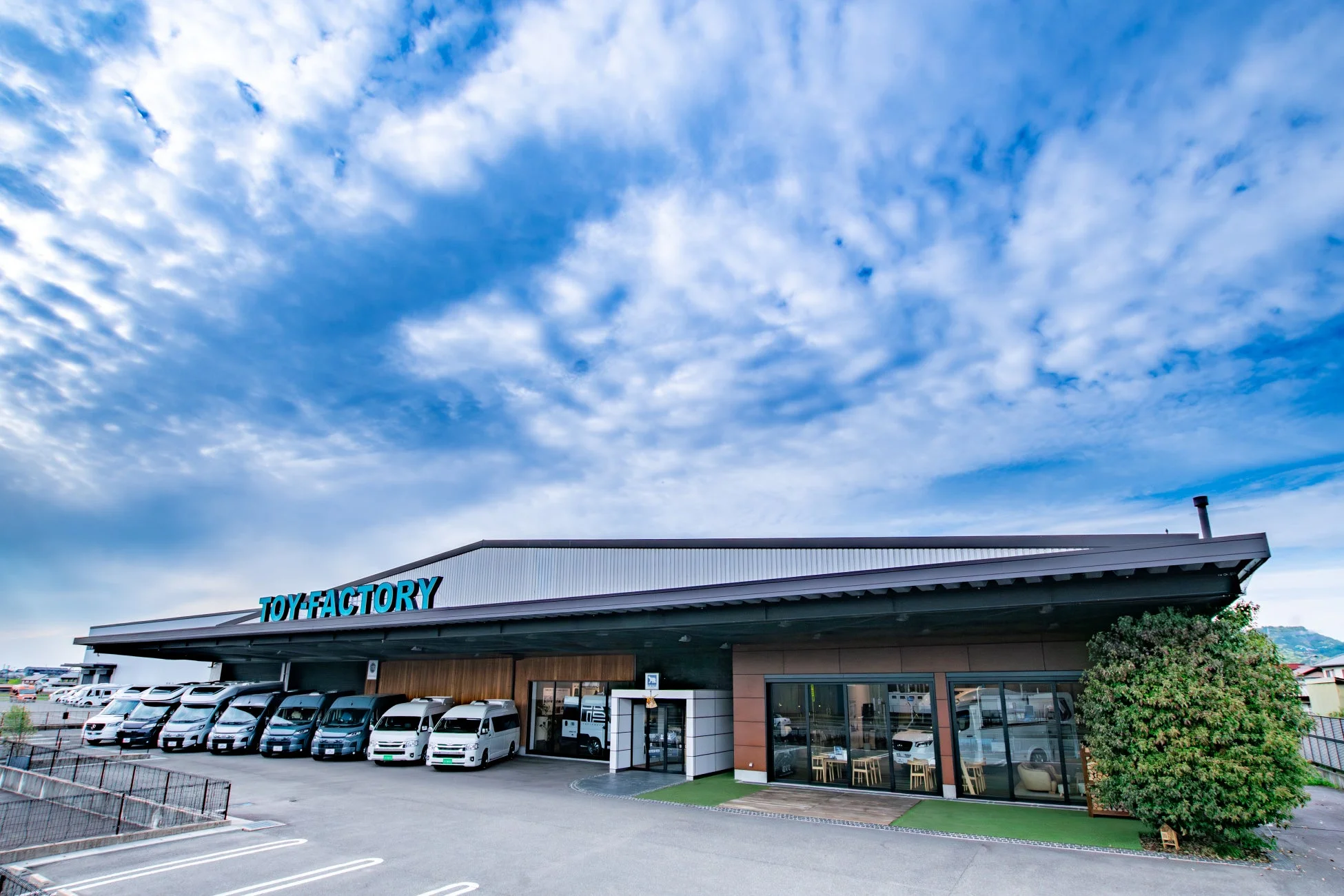 「TOY FACTORY」の看板がある建物とキャンピングカー
