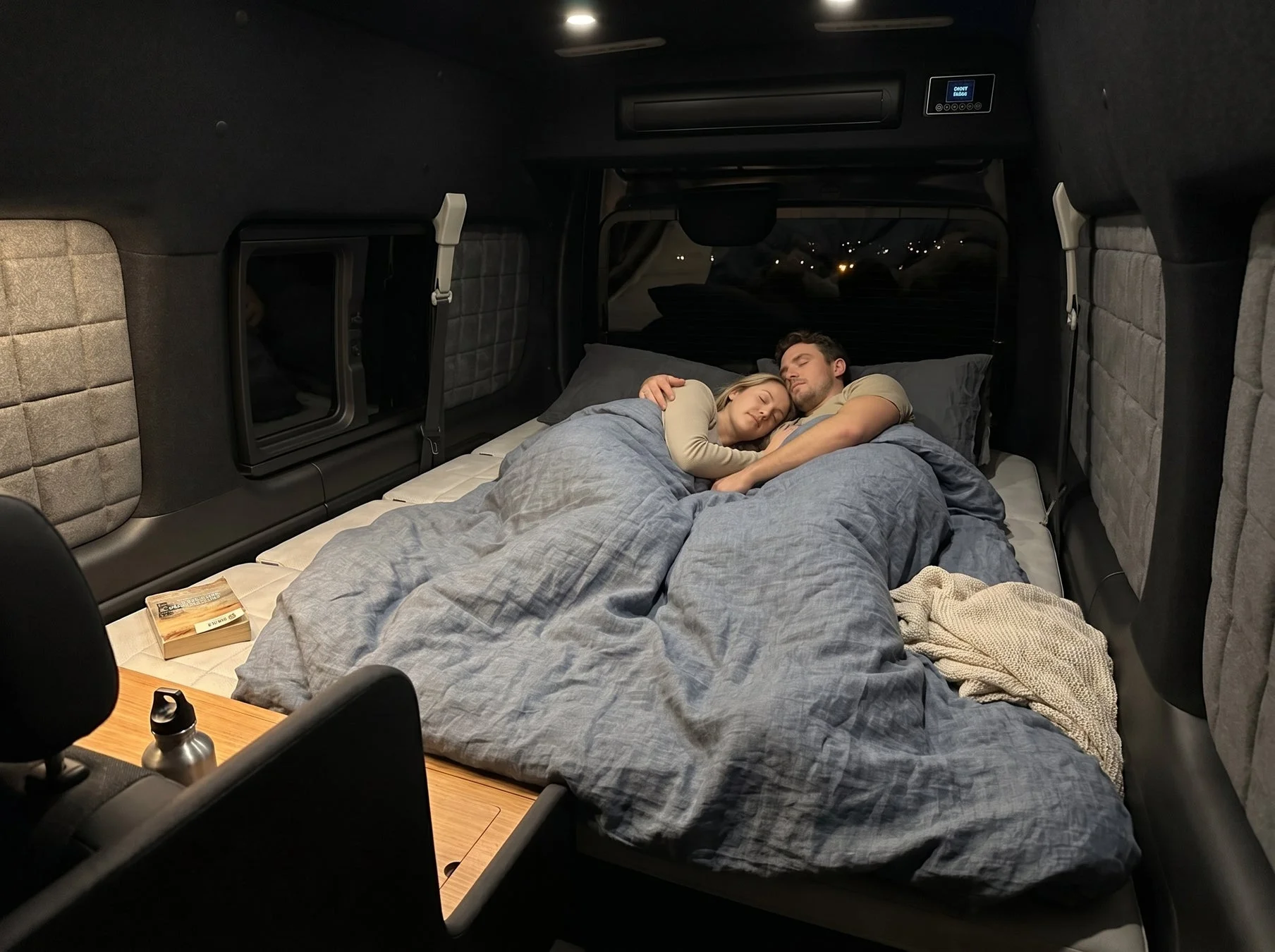キャンピングカーのベッドで安らかに眠るカップル