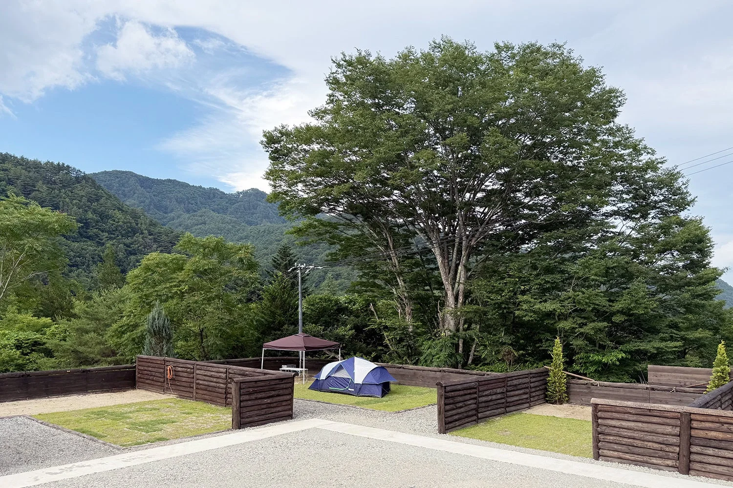 青いテントが設置されたキャンプサイトの風景