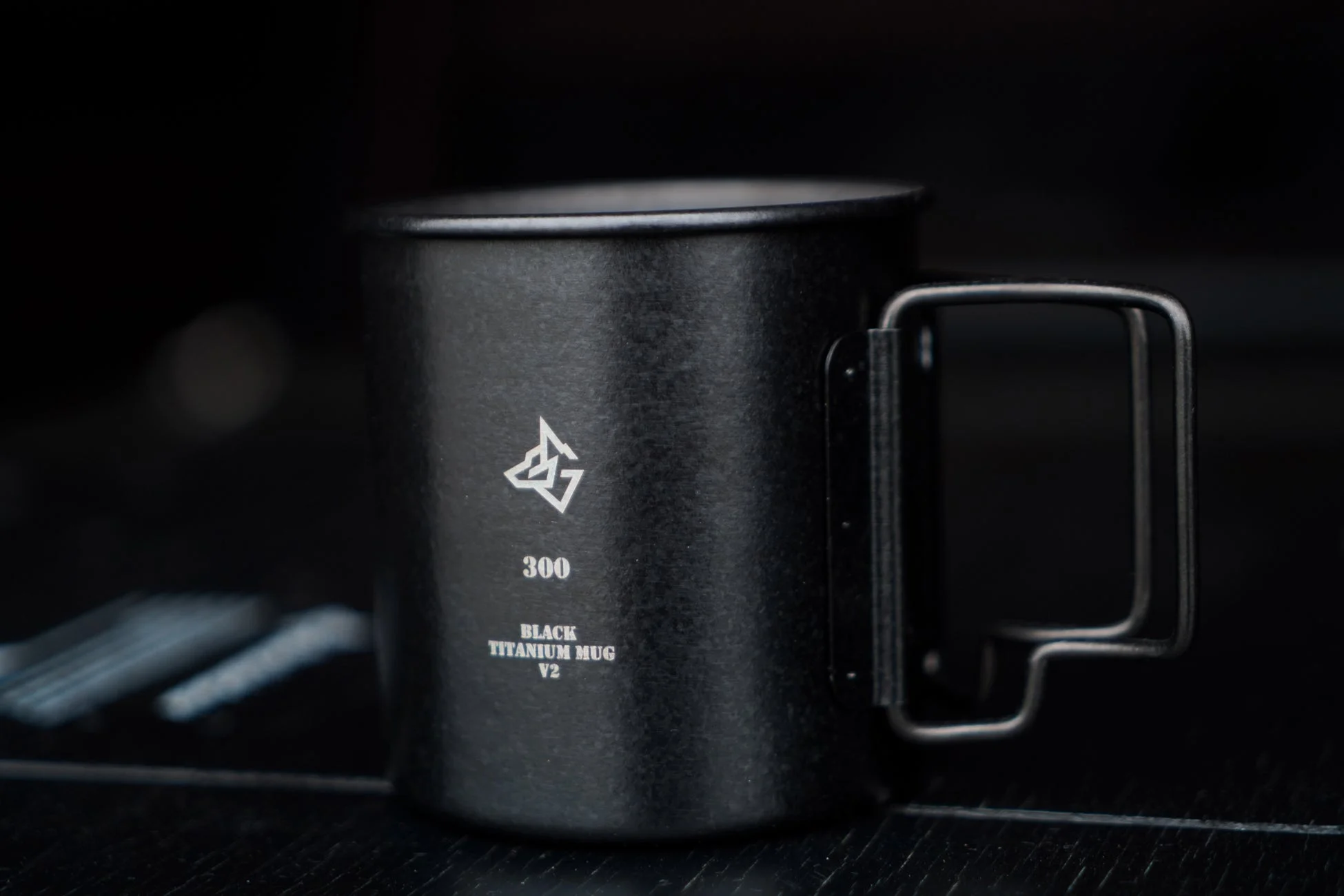暗い背景に置かれた黒いチタン製マグカップのクローズアップ画像です。