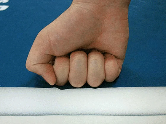 拳でマットを押す様子