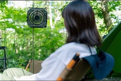 キャンプで涼む女性とポータブルファン