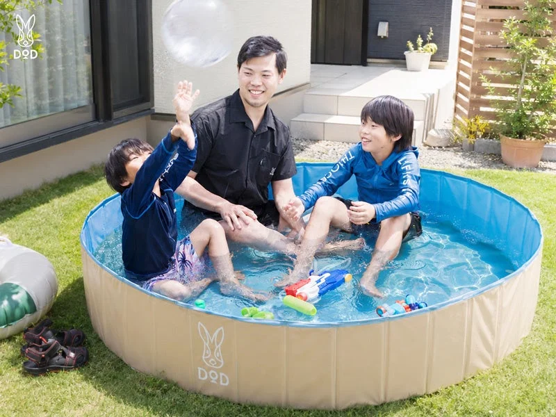 庭のプールで水遊びを楽しむ家族
